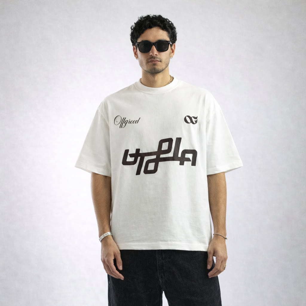 Man wearing a white t-shirt with black graphics and text on a plain background