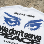 White t-shirt with blue eyes and text on a concrete surface